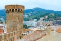 Old tower and stone walls against background of resort town of Tossa de Mar and mountains, Costa Brava, Catalonia, Spain Royalty Free Stock Photo