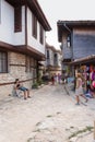 Old Town of Nesebar, a cozy street. People walk along narrow street, go sightseeing and buy souvenirs