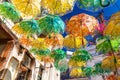 Old Town Street decorated with umbrellas of different colours on summer sunny day