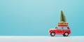 Old toy car with Christmas decorations and pine tree on the roof. Christmas is coming concept on light blue background with copy Royalty Free Stock Photo