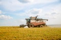 old tracktor plows the field. harvester harvests wheat from a sown agricultural field Royalty Free Stock Photo