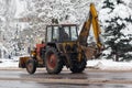 Old tractor cleans snow on city