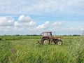 Old tractor cut grass in meadow, Lithuania