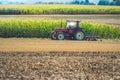 old tractor equipped with a plow in action in a field close-up Royalty Free Stock Photo