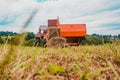 Old tractor in the field, forage harvesting for the winter, press and hay, pressing dry grass Royalty Free Stock Photo