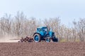 An old tractor in the field plows the land. Spring landscape of a countryside, a farm Royalty Free Stock Photo