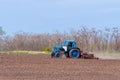 An old tractor in the field plows the land. Spring landscape of a countryside, a farm Royalty Free Stock Photo