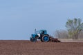 An old tractor in the field plows the land. Spring landscape of a countryside, a farm Royalty Free Stock Photo