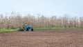 An old tractor in the field plows the land. Spring landscape of a countryside, a farm Royalty Free Stock Photo