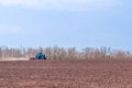 An old tractor in the field plows the land. Spring landscape of a countryside, a farm Royalty Free Stock Photo