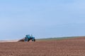 An old tractor in the field plows the land. Spring landscape of a countryside, a farm Royalty Free Stock Photo