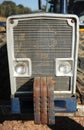 Front view of an old agricultural tractor with iron counterweights.