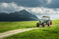 Old tractor on meadow. Beautiful mountain view in the Alps Royalty Free Stock Photo