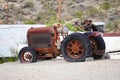 an old tractor sits in front of an abandoned building and rusty Royalty Free Stock Photo