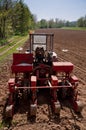 Old tractor with sower parked on worked field upside view