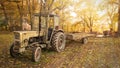 An old tractor standing in the countryside in autumn scenery.