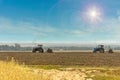 Old tractors with seeders on beautiful sunny agricultural landscape.