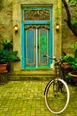 Old traditional ancient wood door with bright vivid tropical color with vintage bicycle Royalty Free Stock Photo