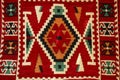 Old traditional carpet with a geometric pattern dark red and white colors in arabic style on bazaar in Mostar, Bosnia and