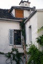 Old traditional house with green plants climbing near to the wooden window shutters in Paris, France Royalty Free Stock Photo