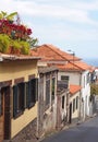 old traditional houses on a downhill street in funchal madeira with orange roof tiles and shuttered windows with colorful potted Royalty Free Stock Photo