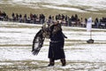 Old traditional kazakh eagle hunter harshly handled with his gol Royalty Free Stock Photo