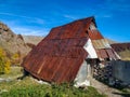 Old traditional mountain house in an  village in the Balkans, with a rusty rooftop and beautiful nature around Royalty Free Stock Photo