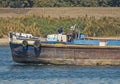 Old traditional river barge traveling through rural landscape