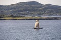 Old traditional sailboat in fjord waters, near Leka island, Norway
