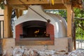 Old traditional stone bread oven stove with burning wood fire an