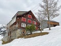 Old traditional swiss rural architecture and alpine livestock farms in the winter ambience of the region over the Lake Walen