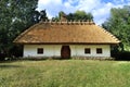 Old traditional Ukrainian rural house with thatched roof and wicker fence in the garden Royalty Free Stock Photo