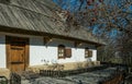 Old traditional village house in the background of the garden. Clay white walls and plank roof