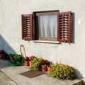 Old traditional window with open wooden shutters and flowers Royalty Free Stock Photo