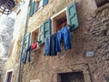 Old traditions in Europe: clothes hung out to dry under a window of a stone house in an ancient Italian village Royalty Free Stock Photo