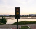 Old Traffic light in turn off damaged is display side river. Evening with sky and river in background. Royalty Free Stock Photo