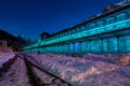 Old train station of Canfranc with the facade illuminated in blue tones on a winter night with snow on the tracks, Huesca, Royalty Free Stock Photo