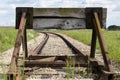 Old train tracks with a wooden stop device. Composition with leading lines. Royalty Free Stock Photo