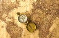 Travel accessories - compass on old, antique world map Royalty Free Stock Photo