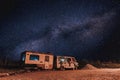 An old truck with milky way in a wasted territory on the outskirts of a small town