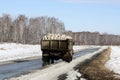 Old Soviet ZIL-130 truck takes firewood to the village along a muddy winter road Royalty Free Stock Photo