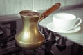 Old turkish copper pot for brewing coffee on stove. Early breakfast. Turkish method of brewing coffee. Royalty Free Stock Photo