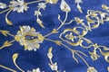 Old Turkish embroidered fabric with golden geometric and floral decorations against a blue background Royalty Free Stock Photo