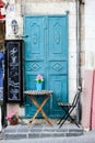 Old turquoise metal door with table and chair as a beautiful vintage background