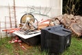 Old TV set and the rest of bulky trash. Old TV thrown away next to a wall with a pile of mixed garbage. Royalty Free Stock Photo