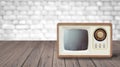 Old tv tunner on a wooden table against a white brick wall. Royalty Free Stock Photo