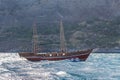 Old two-masted yacht in the sea against rocky shore. Royalty Free Stock Photo