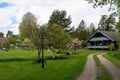 Old two story wooden house by the road. Countryside. Villa cottage made of dark wood with large terrace and balcony. Garden design Royalty Free Stock Photo