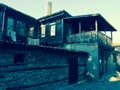 Old two-story wooden house with a stone base.