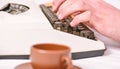 Old typewriter and authors hands. Male hands type story or report using white vintage typewriter equipment close up Royalty Free Stock Photo